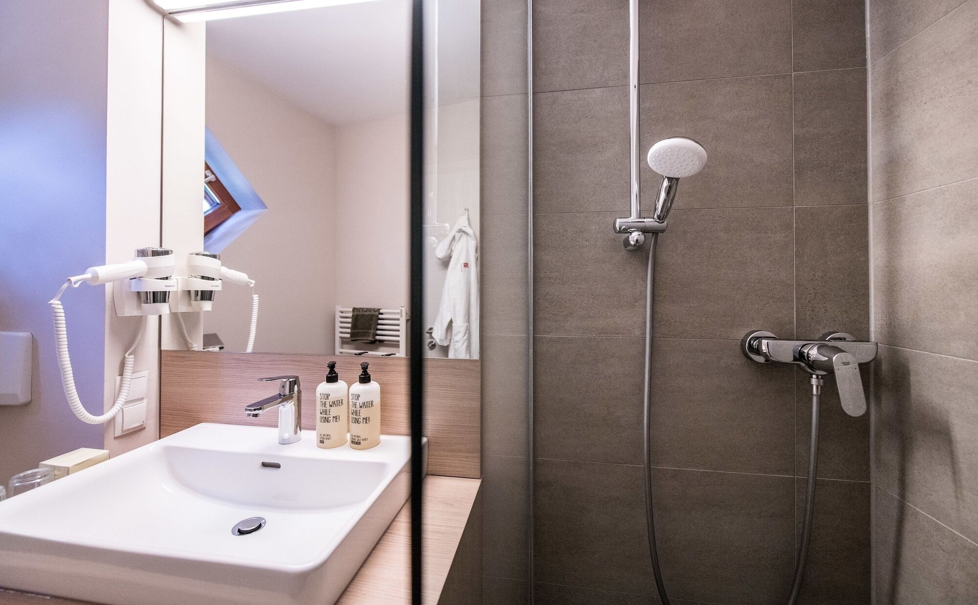 Ein modernes Badezimmer mit Waschbecken, Duschbrause und Handtuchhalter.