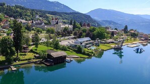 A lakeside town with a mix of residential and commercial buildings, a dock, and a bridge. - Kaiser Franz Josef (Millstatt)