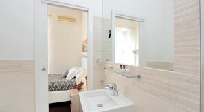 A bathroom with a white sink, a mirror, and a shower area. - Relais Incantesimo Vaticano (Rome)
