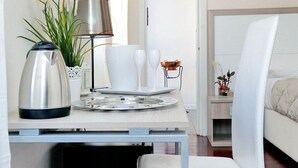 A modern hotel room with a minimalist design, featuring a bed, a bedside table with a lamp, and a small plant. - Relais Incantesimo Vaticano (Rome)