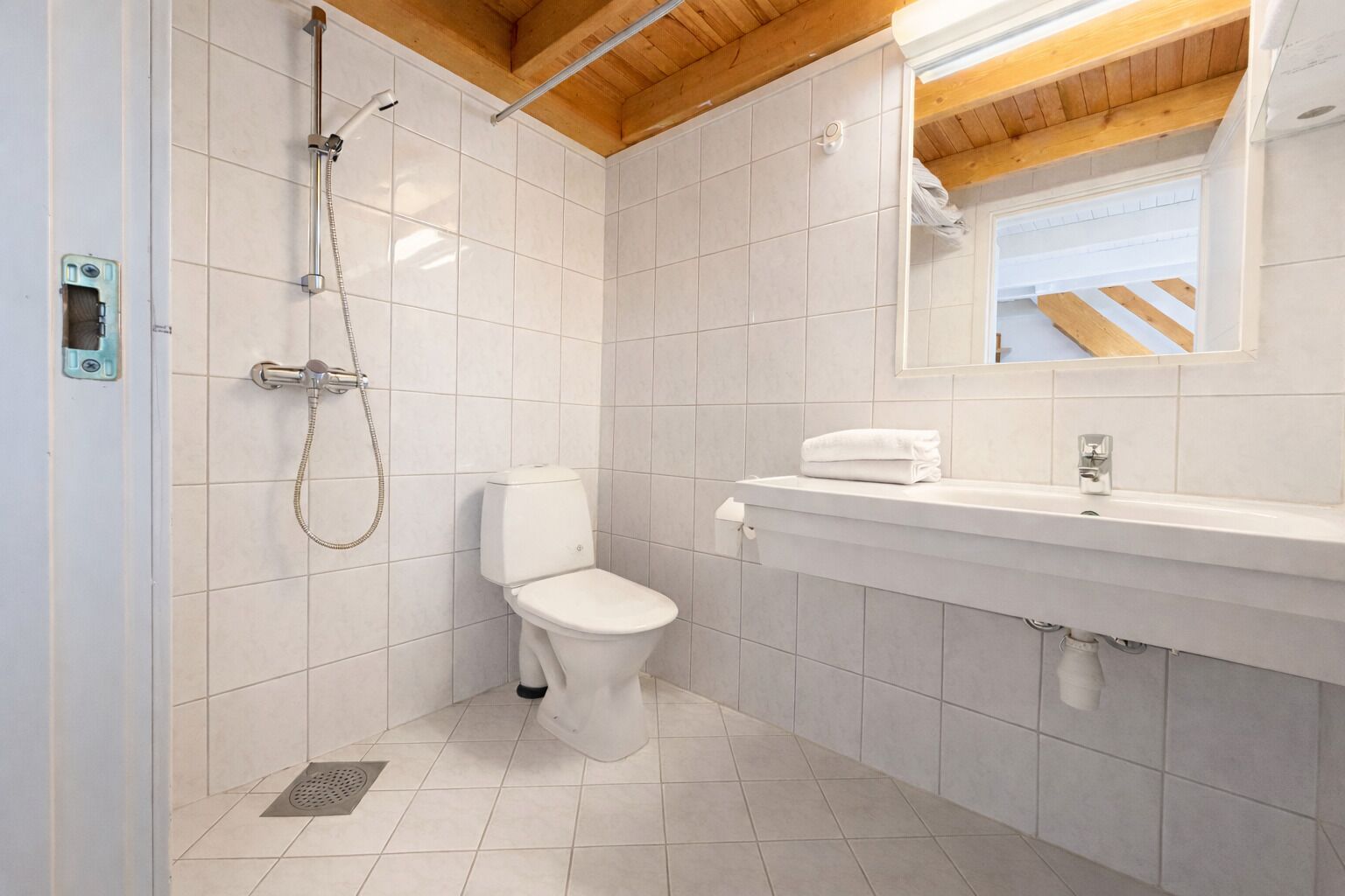A bathroom with a shower, toilet, and sink.