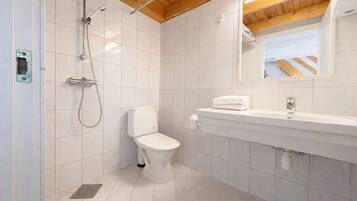 A bathroom with a shower, toilet, and sink.