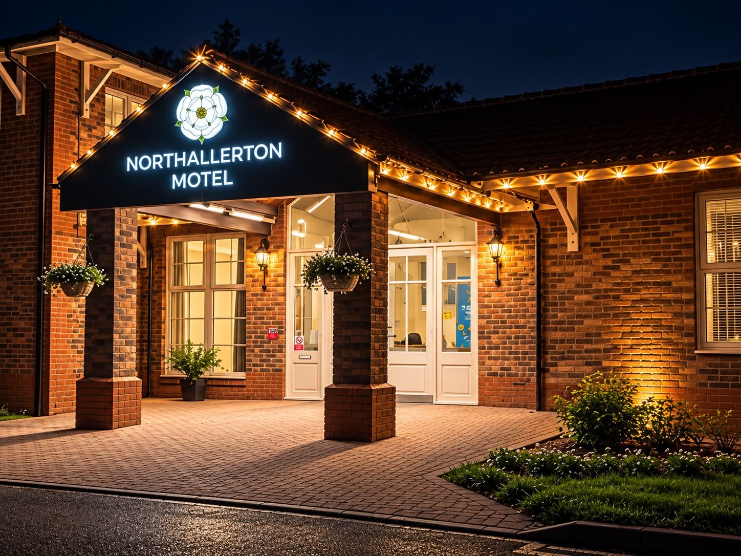 The exterior of Northallerton Hotel with a brick facade, a marquee sign, and outdoor lighting.