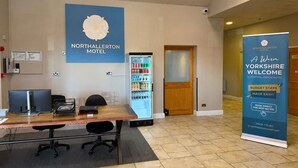A reception area with a reception desk, computer, and a vending machine. - Northallerton Motel (Northallerton)