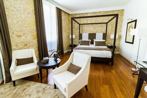 A hotel room with a four-poster bed, two armchairs, a small table, and a lamp. - Hotel Villa Fanny (Cagliari)