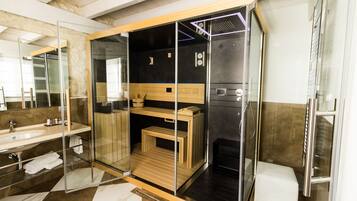 A modern bathroom with a glass-enclosed shower, a wooden vanity, and a large mirror.