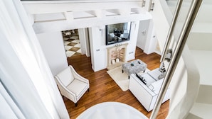 A modern interior with a white sofa, a white armchair, a small table, and a fireplace. - Hotel Villa Fanny (Cagliari)