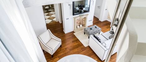 A modern interior with a white sofa, a white armchair, a small table, and a fireplace.