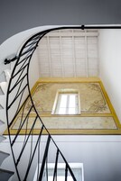 Una escalera de caracol con interior blanco y una ventana en la parte superior.