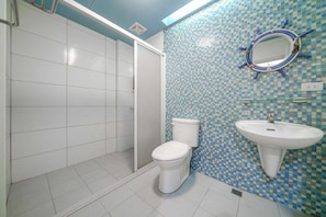 A bathroom with a white toilet, a sink, and a shower area. - Silver Netherlands B and B (Luodong)
