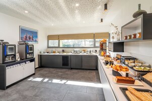 Una cocina moderna con barra americana, un ventanal grande y diferentes alimentos a la vista.