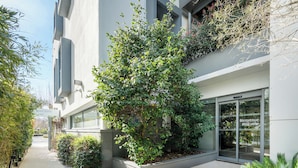 A modern building with a welcoming entrance, a pathway, and greenery. - Best Western Plus Central Park Hotel & Spa (La Rochelle)