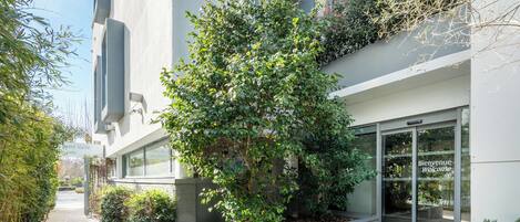 Un edificio moderno con una entrada acogedora, un sendero y vegetación.