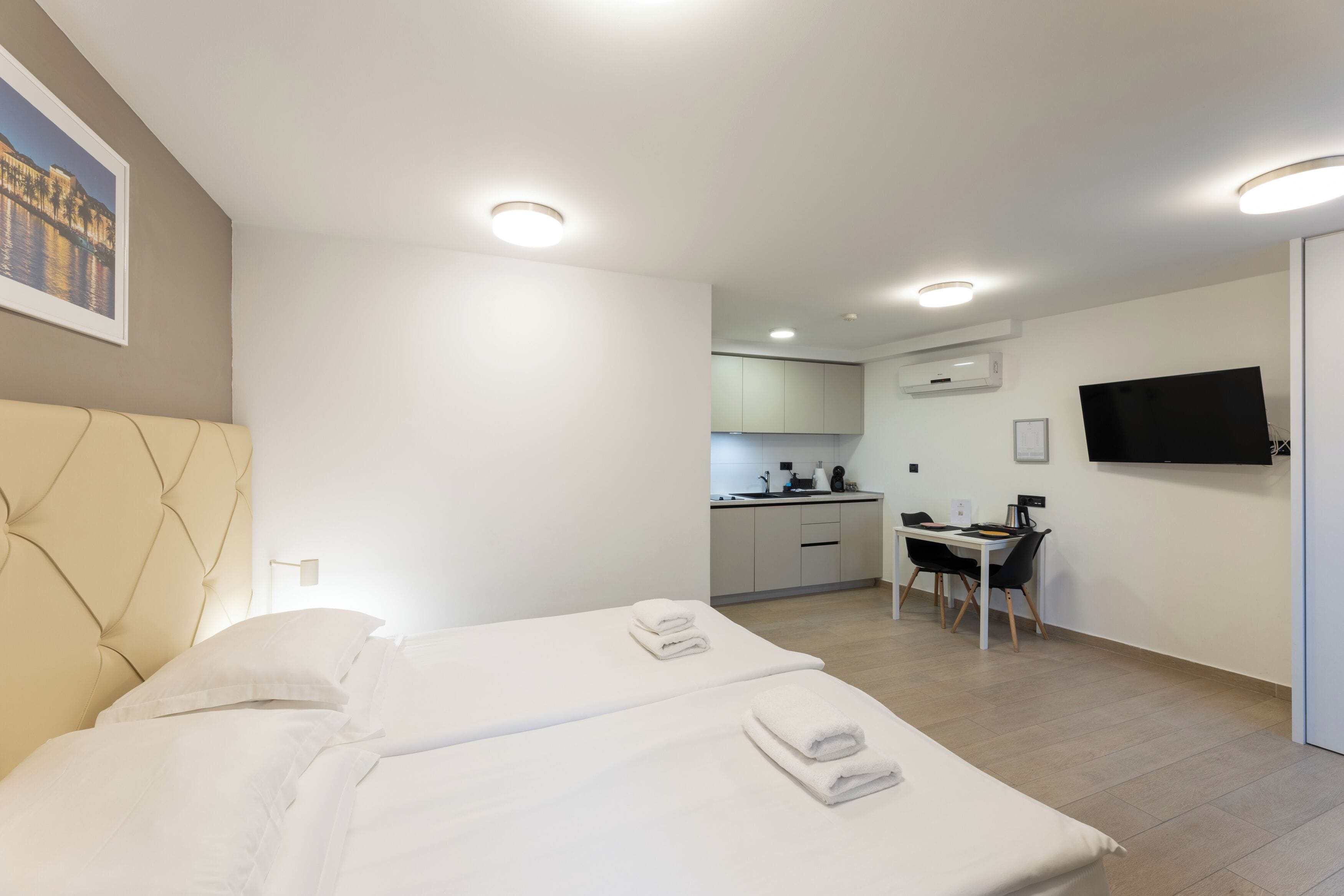 Ein modernes Hotelzimmer mit einem großen Bett, einem Schreibtisch und einem Fernseher.
