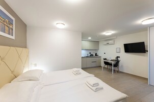 Ein modernes Hotelzimmer mit einem großen Bett, einem Schreibtisch und einem Fernseher.