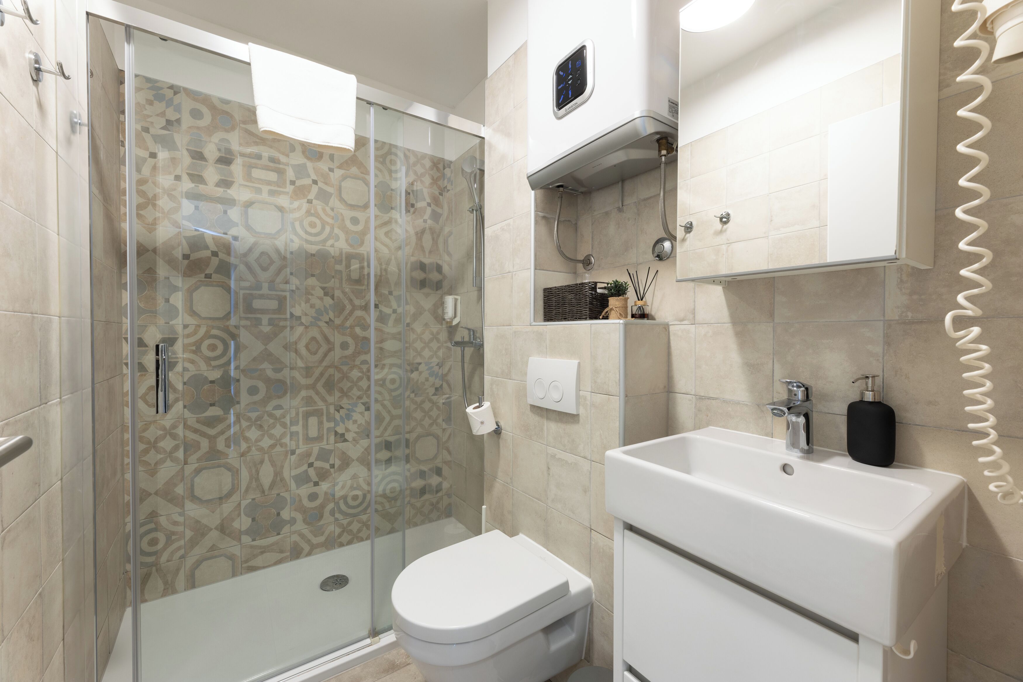 A modern bathroom with a shower, toilet, and sink.