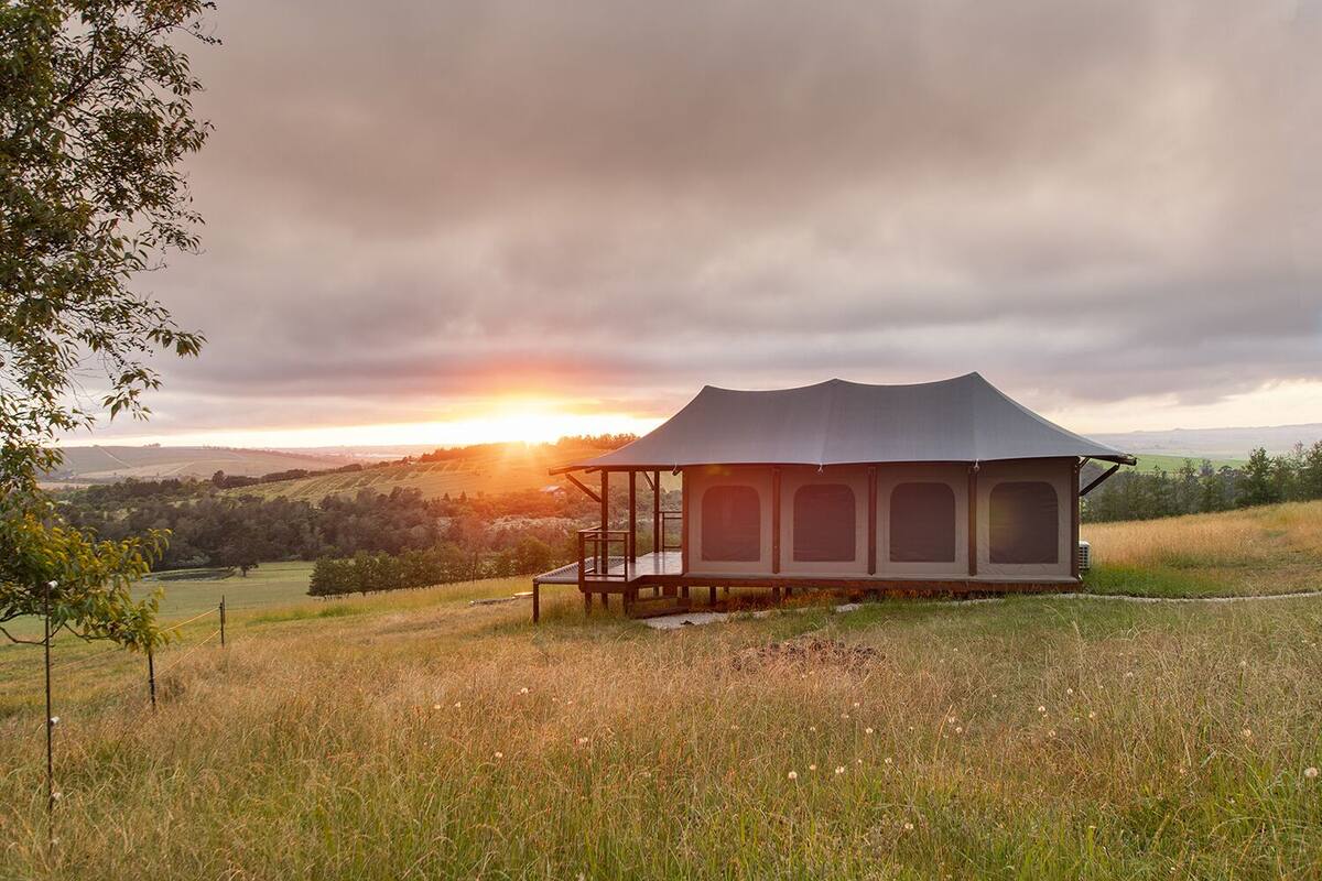 A single-story, open-air structure with a flat roof and a covered porch area.