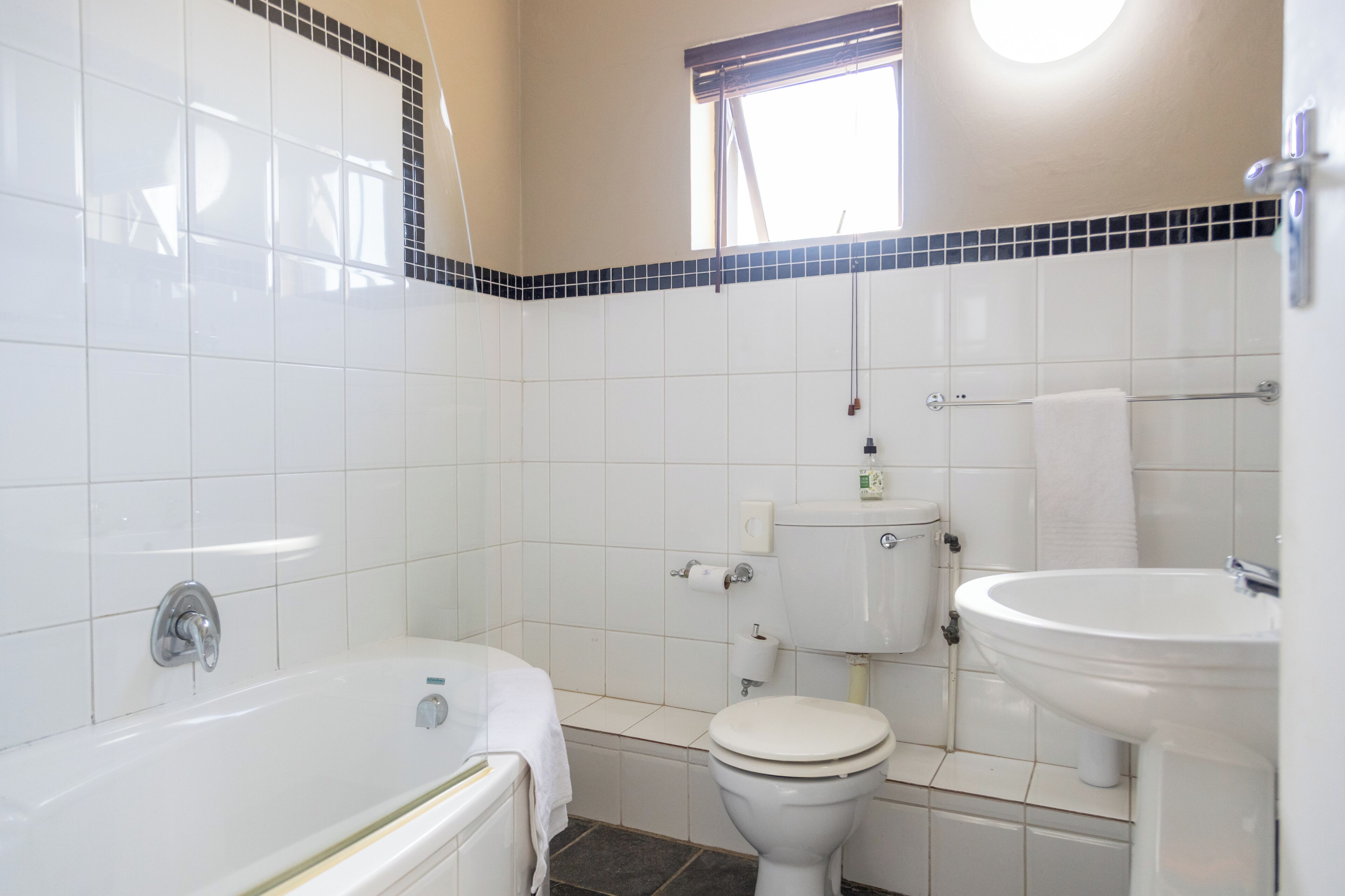 Un baño con bañera, inodoro y lavabo.