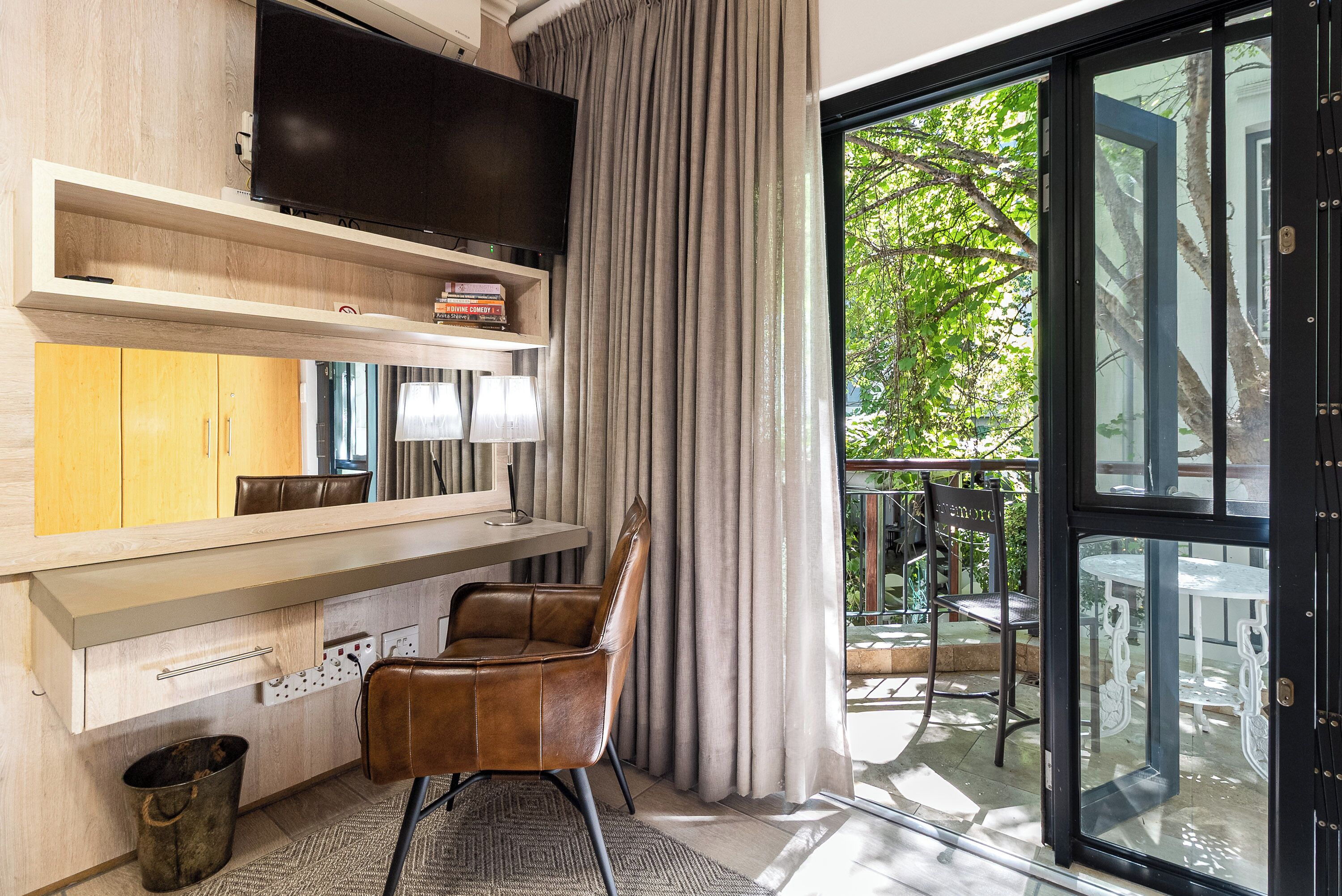 A modern kitchen with a built-in TV, wooden cabinets, and a dining area with a chair and table.