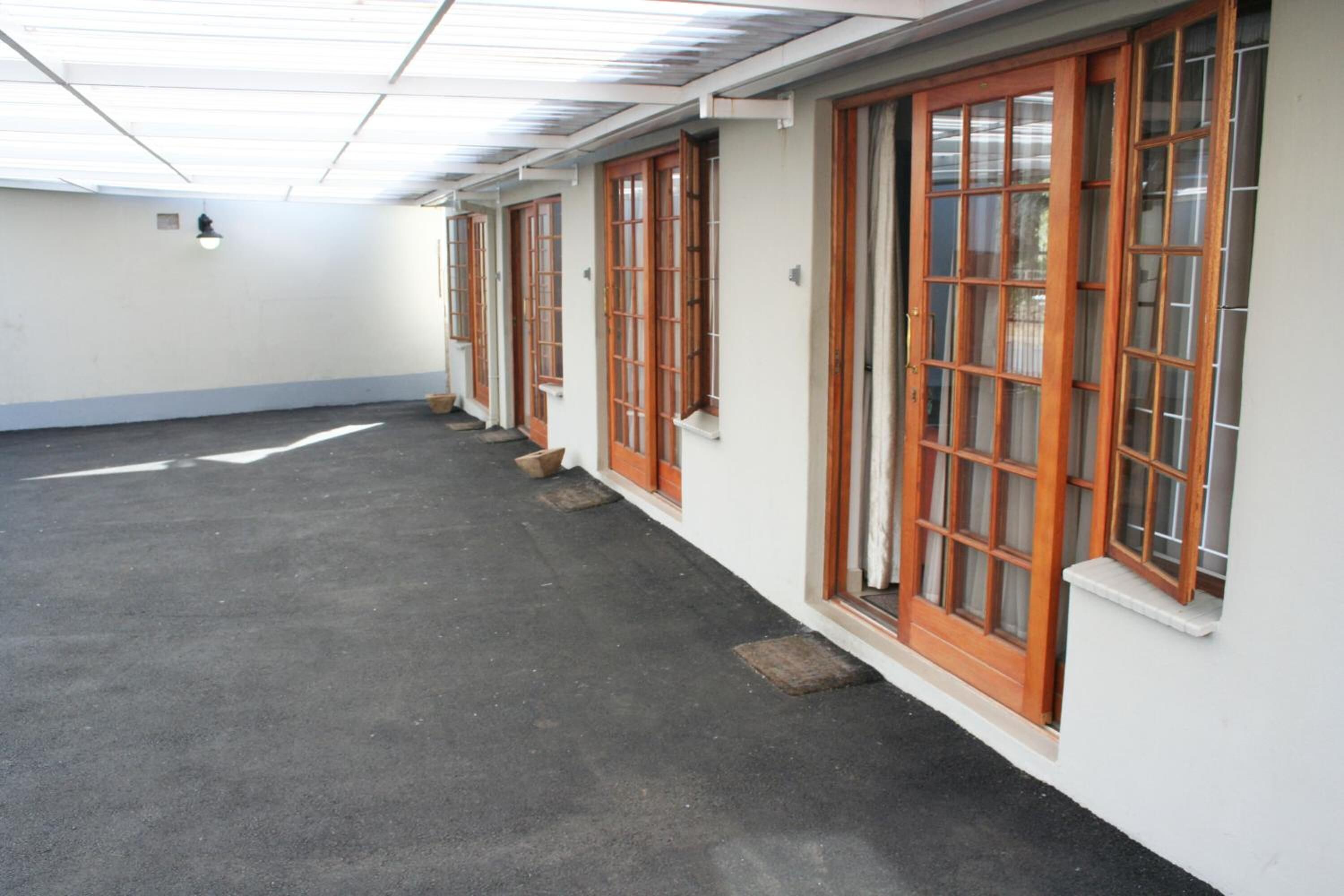 A corridor with wooden-framed windows and a tiled ceiling.