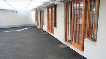 A corridor with wooden-framed windows and a tiled ceiling.
