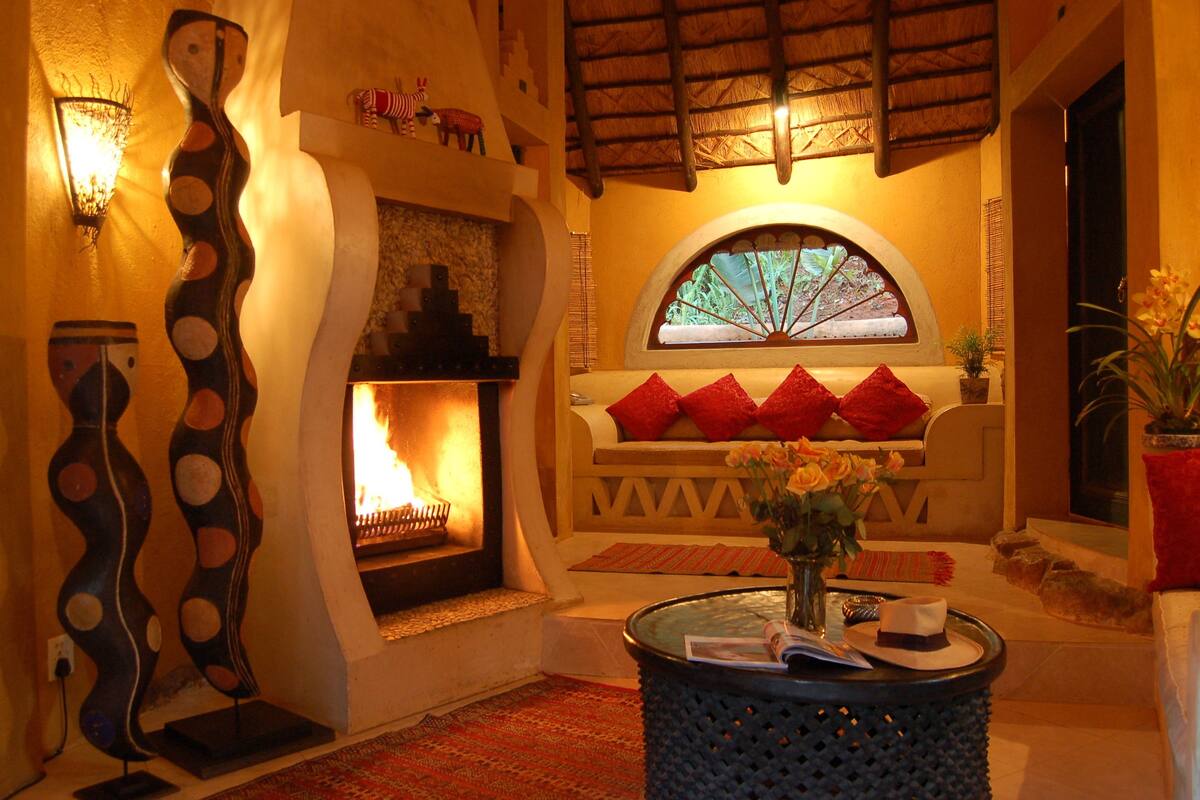A cozy living room with a fireplace, a decorative wall piece, and a comfortable seating area.