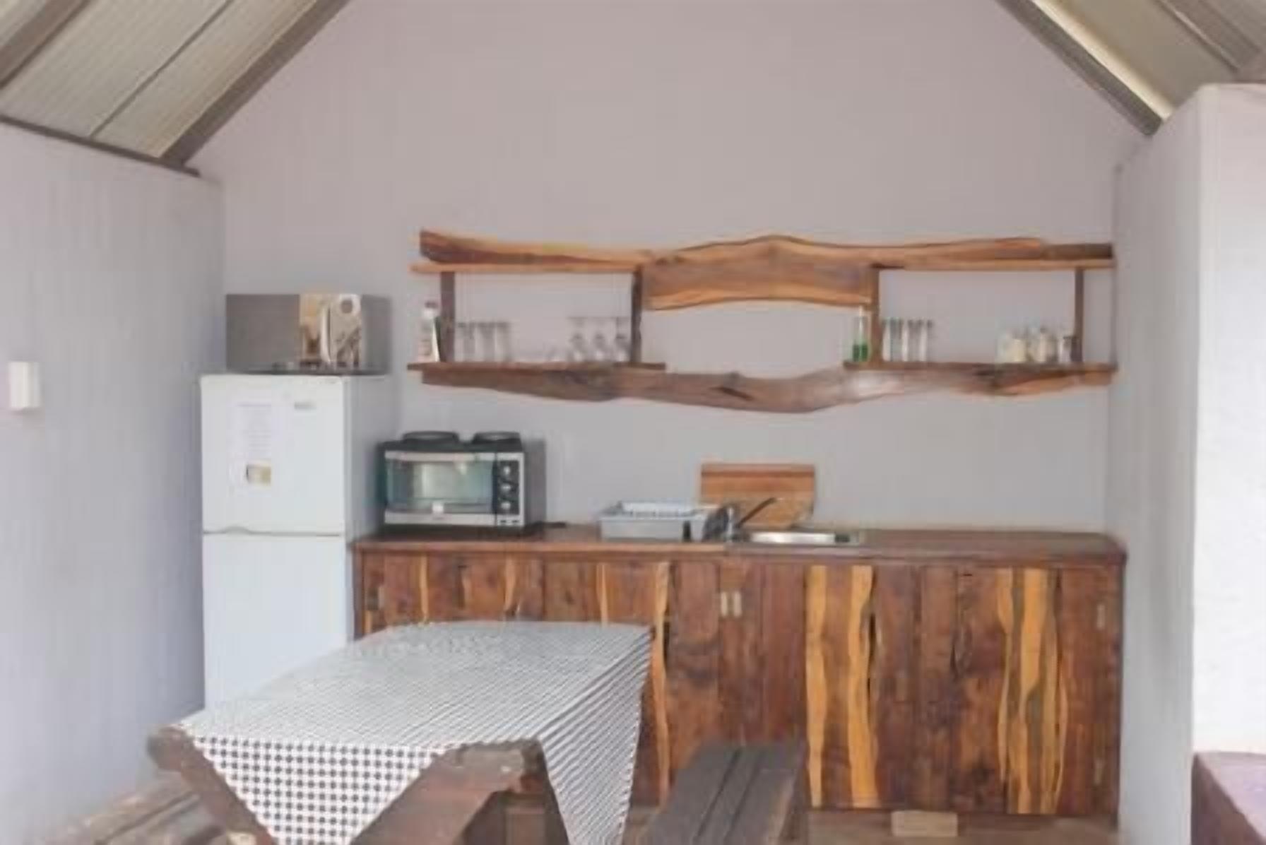 A compact kitchen with a microwave, toaster, and wooden cabinets.