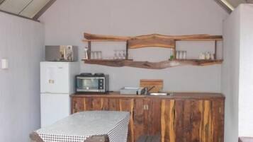 A compact kitchen with a microwave, toaster, and wooden cabinets.