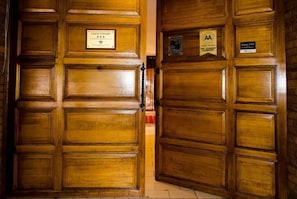 Une porte en bois portant une plaque indiquant qu’il s’agit d’une maison d’hôtes et qu’elle est agréée par l’association AA.
