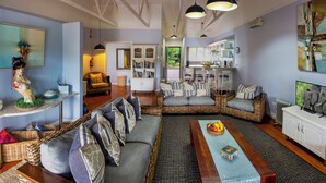 A spacious living room with a large sectional sofa, a dining area, and a kitchen in the background. - Dungbeetle River Lodge (Colchester)