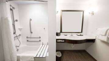 Een moderne badkamer met een inloopdouche, handgrepen, een bad, een wastafel en een spiegel.