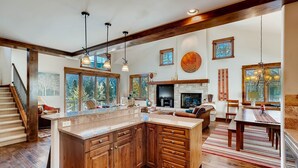 A spacious kitchen with wooden cabinets, a large island, and pendant lighting. - Keystone Private Homes by Vail Resorts (Keystone)