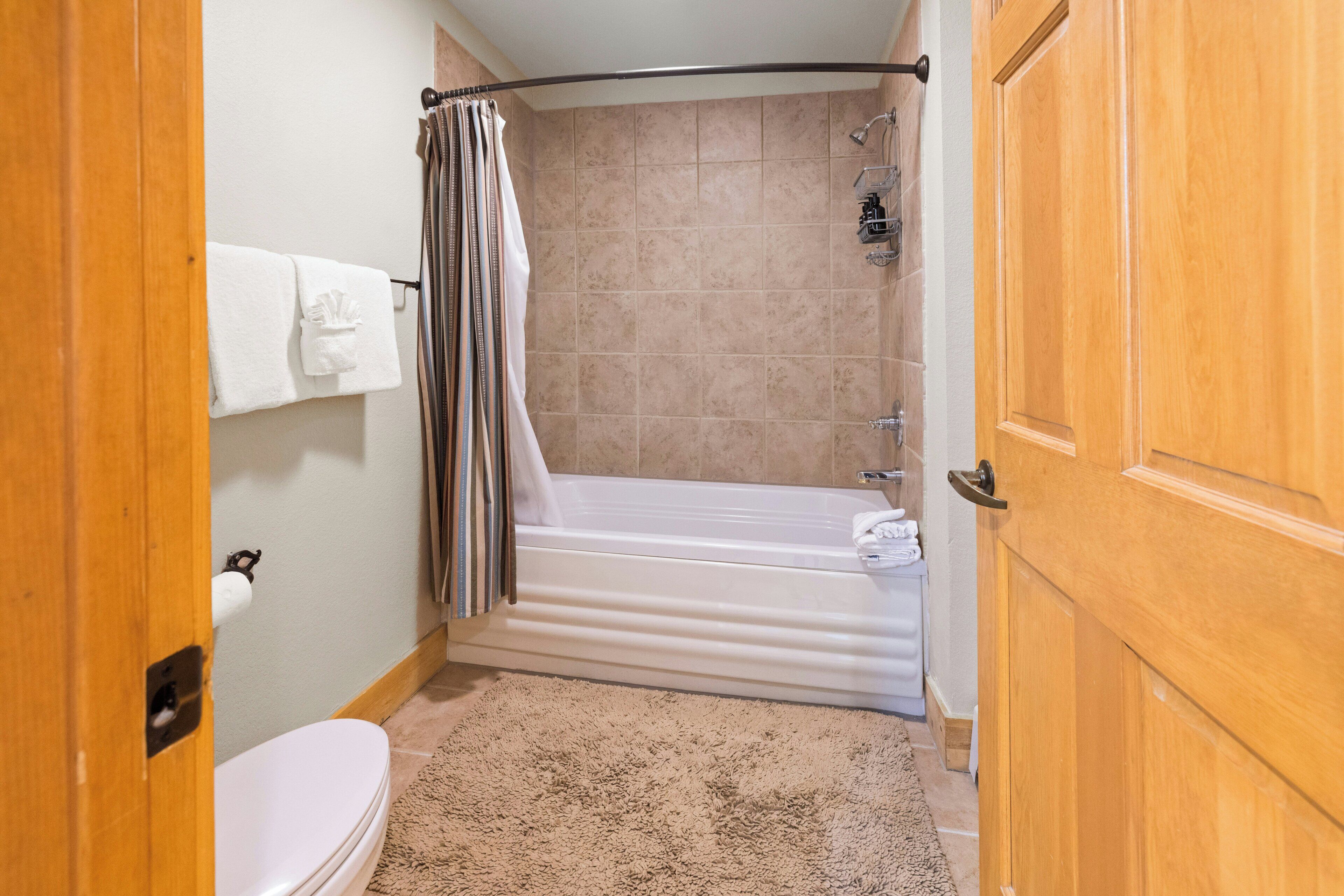 A bathroom with a bathtub, toilet, and shower.