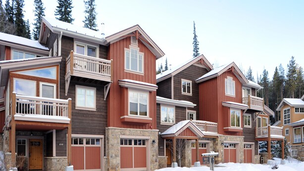 A multi-story residential building with a stone foundation, wooden exterior, and multiple balconies. - East Keystone by Vail Resorts (Keystone)