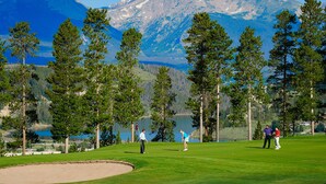 A golf course with a lake and mountains in the background. - East Keystone by Vail Resorts (Keystone)