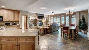A spacious kitchen with granite countertops, wooden cabinets, and a stone floor. - Timbers & Lone Eagle by Vail Resorts (Keystone)