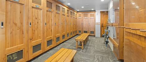 A locker room with wooden lockers, benches, and a bicycle rack.