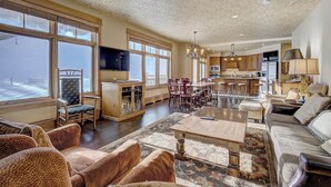 A spacious living room with a large window, a dining area, and a kitchen. - Timbers & Lone Eagle by Vail Resorts (Keystone)