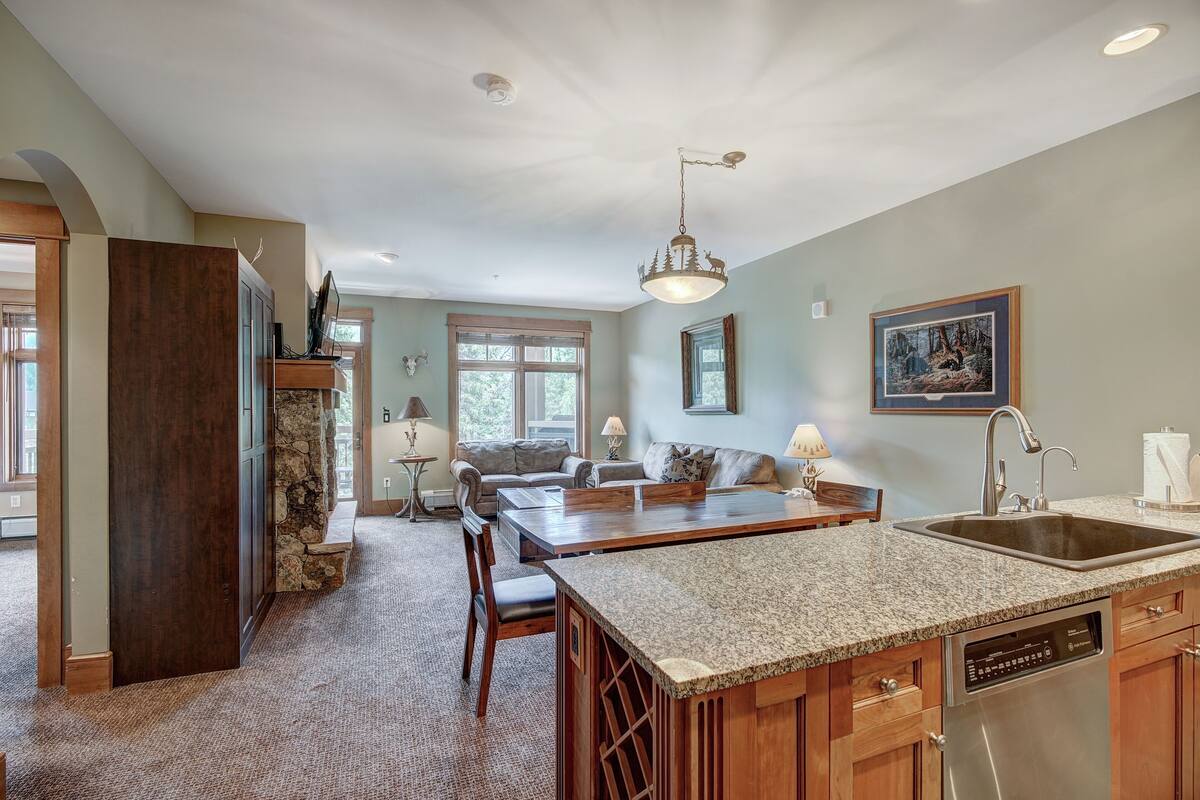 A spacious kitchen with granite countertops, a built-in dishwasher, and a large island.
