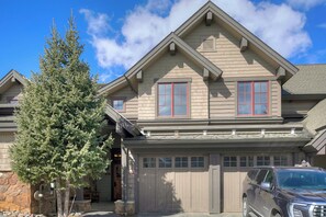 A two-story house with a garage, a driveway, and a large evergreen tree. - River Mountain Lodge, A Vail Resorts Property (Breckenridge)