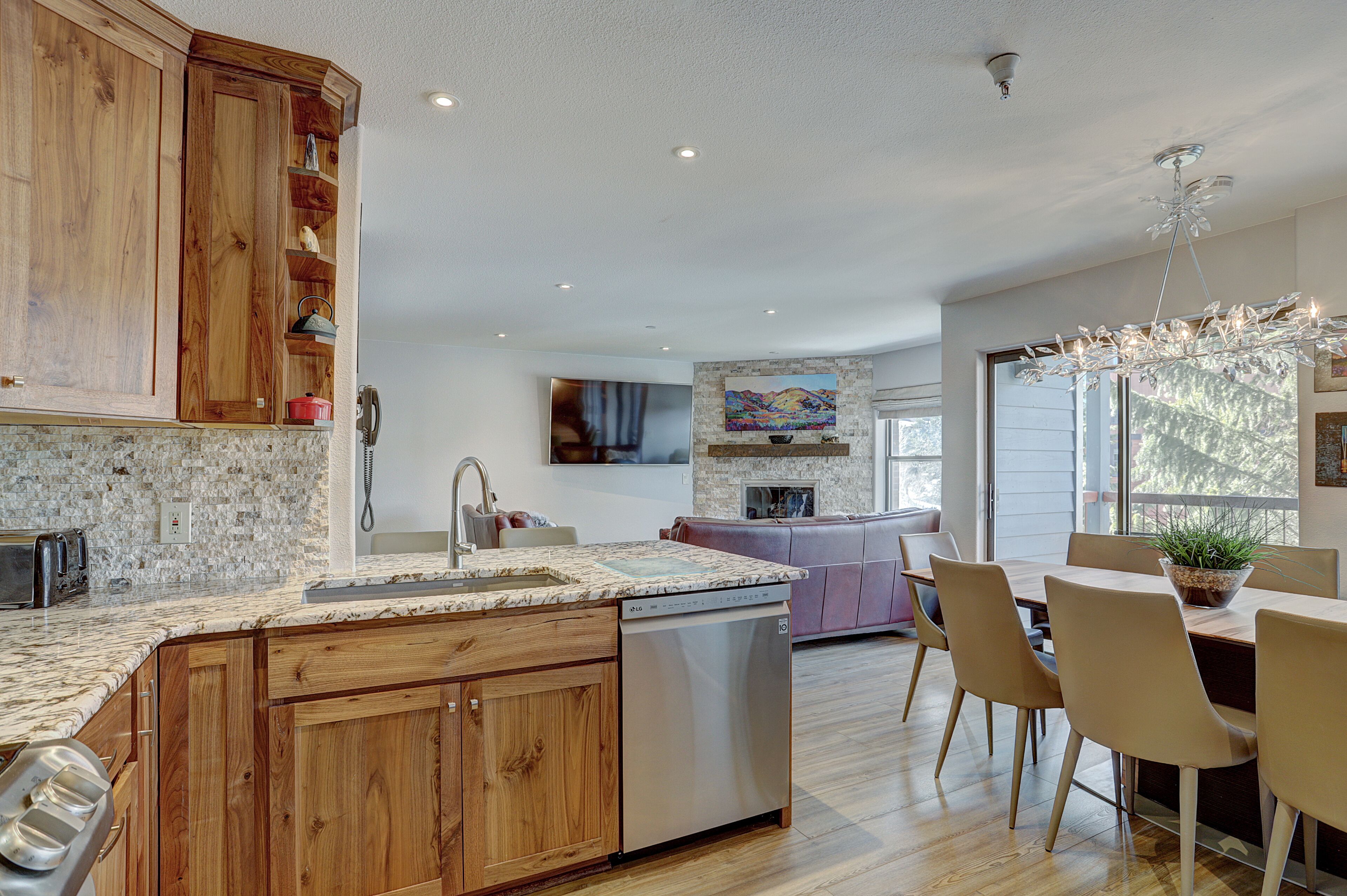 A modern kitchen with wooden cabinets, granite countertops, and a built-in dishwasher.