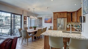 Een moderne keuken met houten kastjes, roestvrijstalen apparatuur en een groot eiland met zitplaatsen.