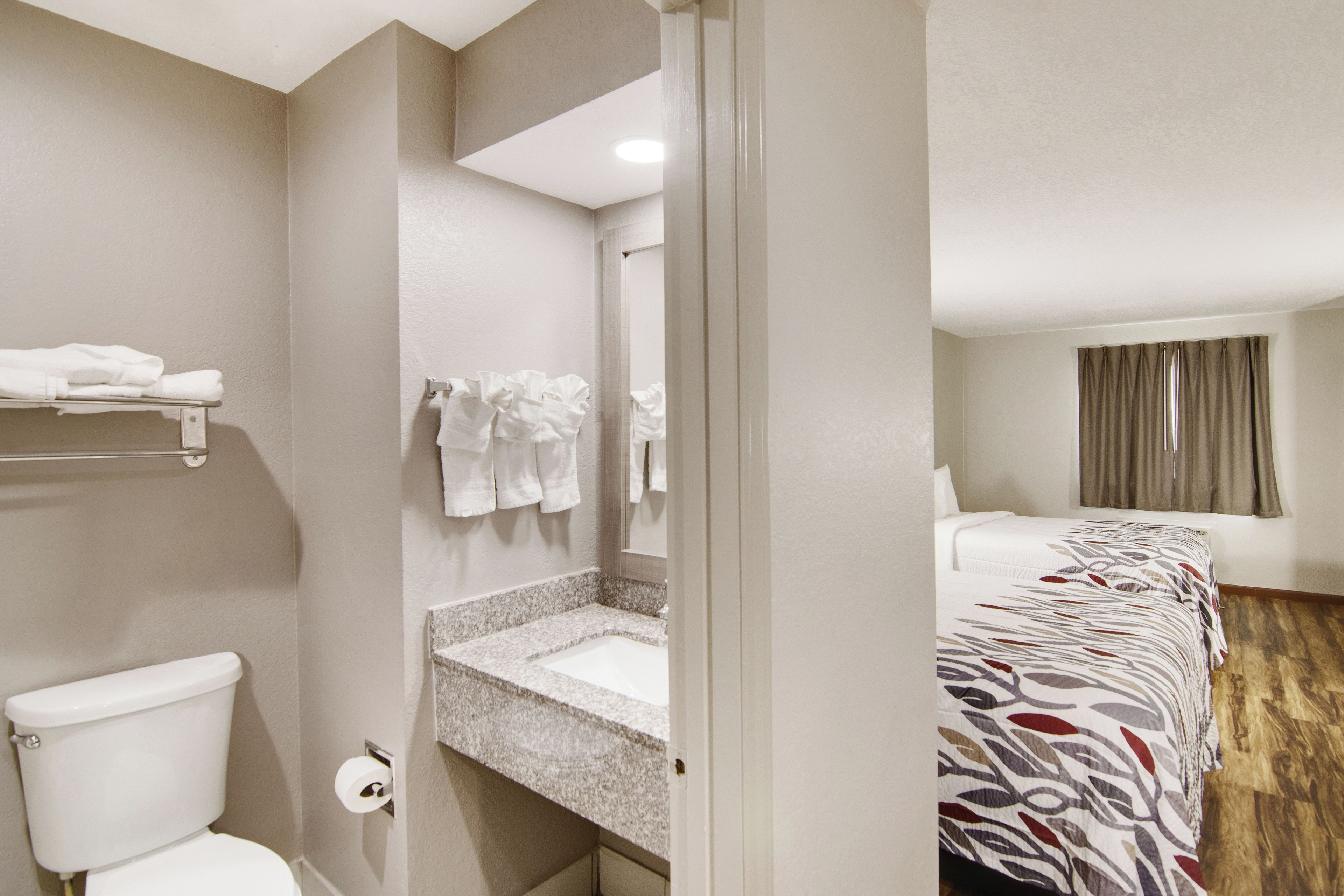 Un baño de hotel con inodoro, lavabo y perchero para toallas.
