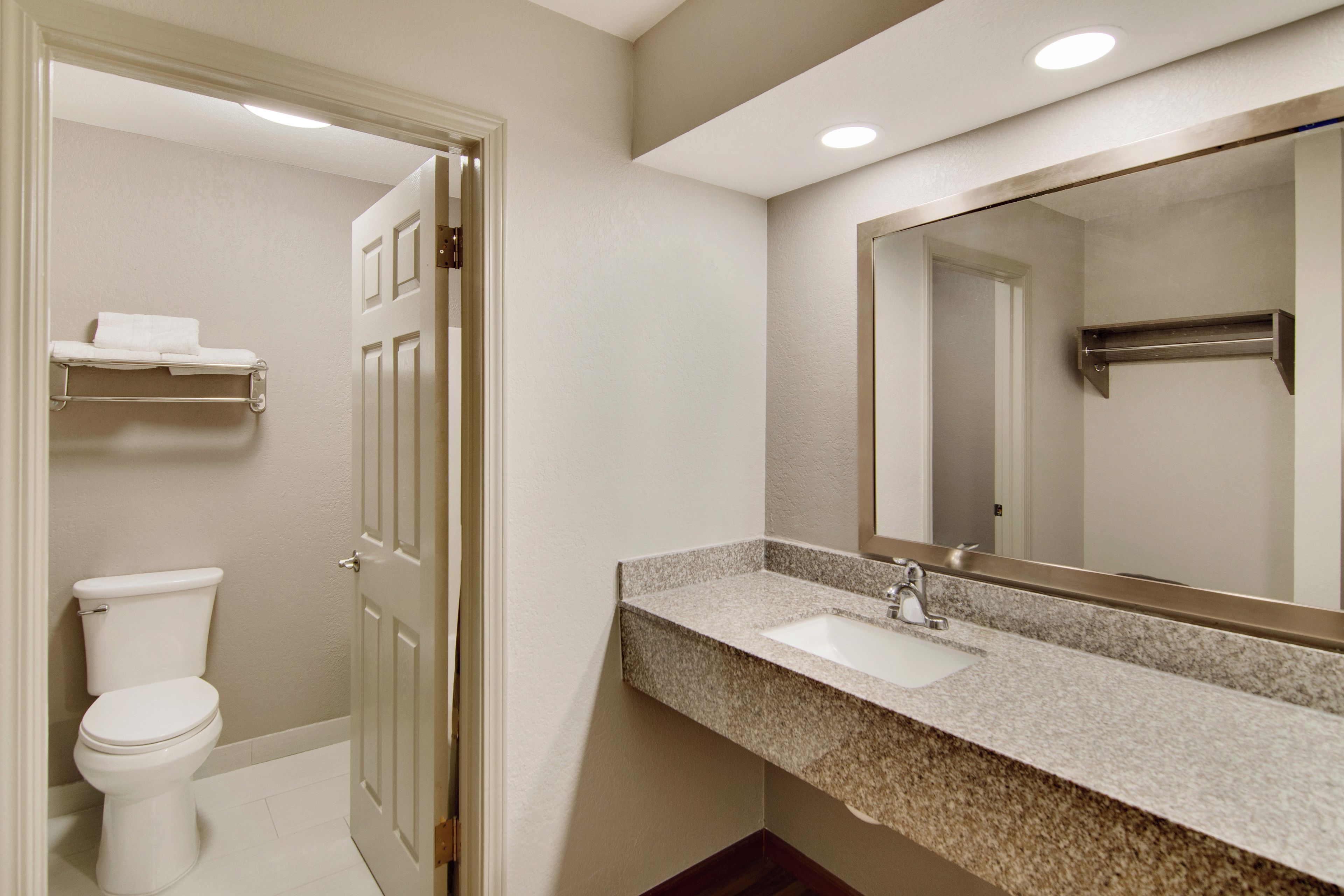 Un baño con inodoro, lavabo y espejo.