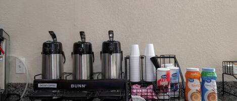 En kaffestation med Bunn-kaffemaskiner, engangskopper og fløde.