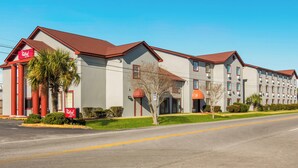 A hotel with a red roof, multiple windows, and a sign indicating a Red Roof Inn. - Red Roof Inn & Suites Pensacola - NAS Corry (Pensacola)