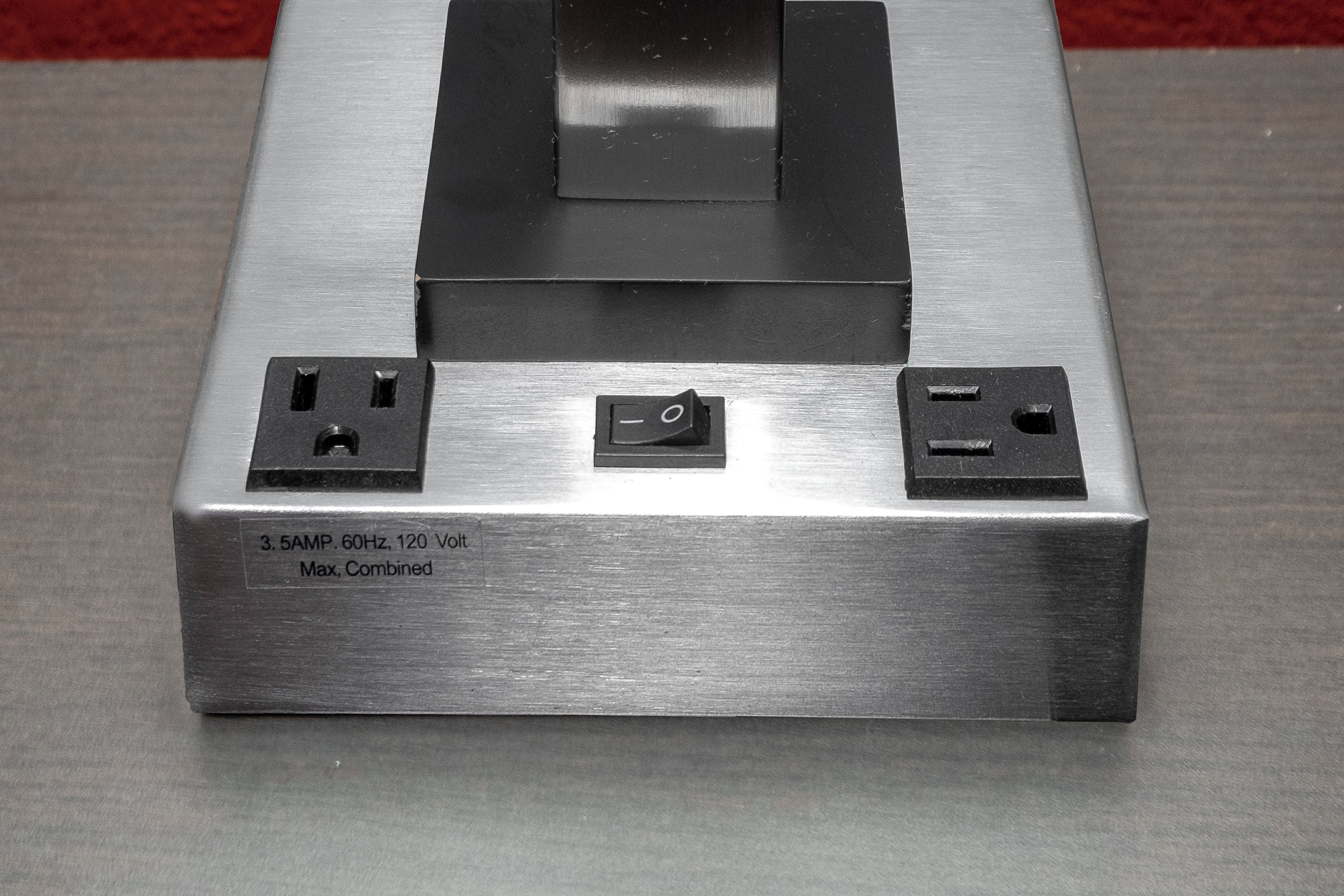 A metallic, rectangular device with two power sockets and a switch on the front, labeled '3.5AMP 60Hz, 120 Volt Max, Combined'.