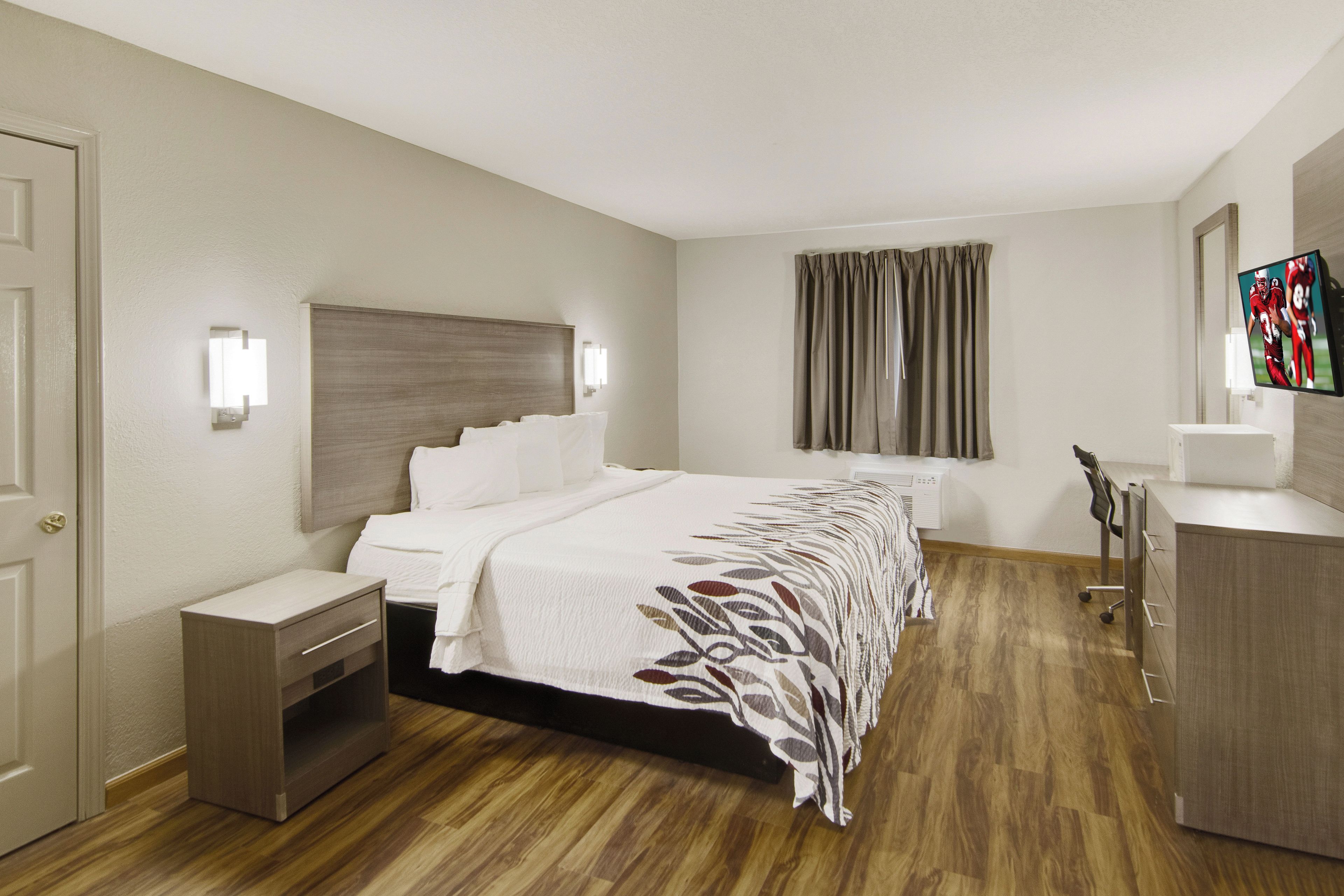 Una habitación de hotel con cama, mesita de noche y armario.