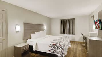 Una habitación de hotel con cama, mesita de noche y armario.