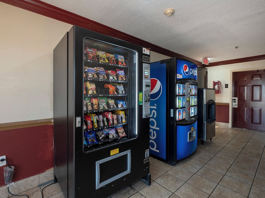 Zona de máquinas expendedoras con opciones de comida para llevar y un refrigerador de Pepsi.